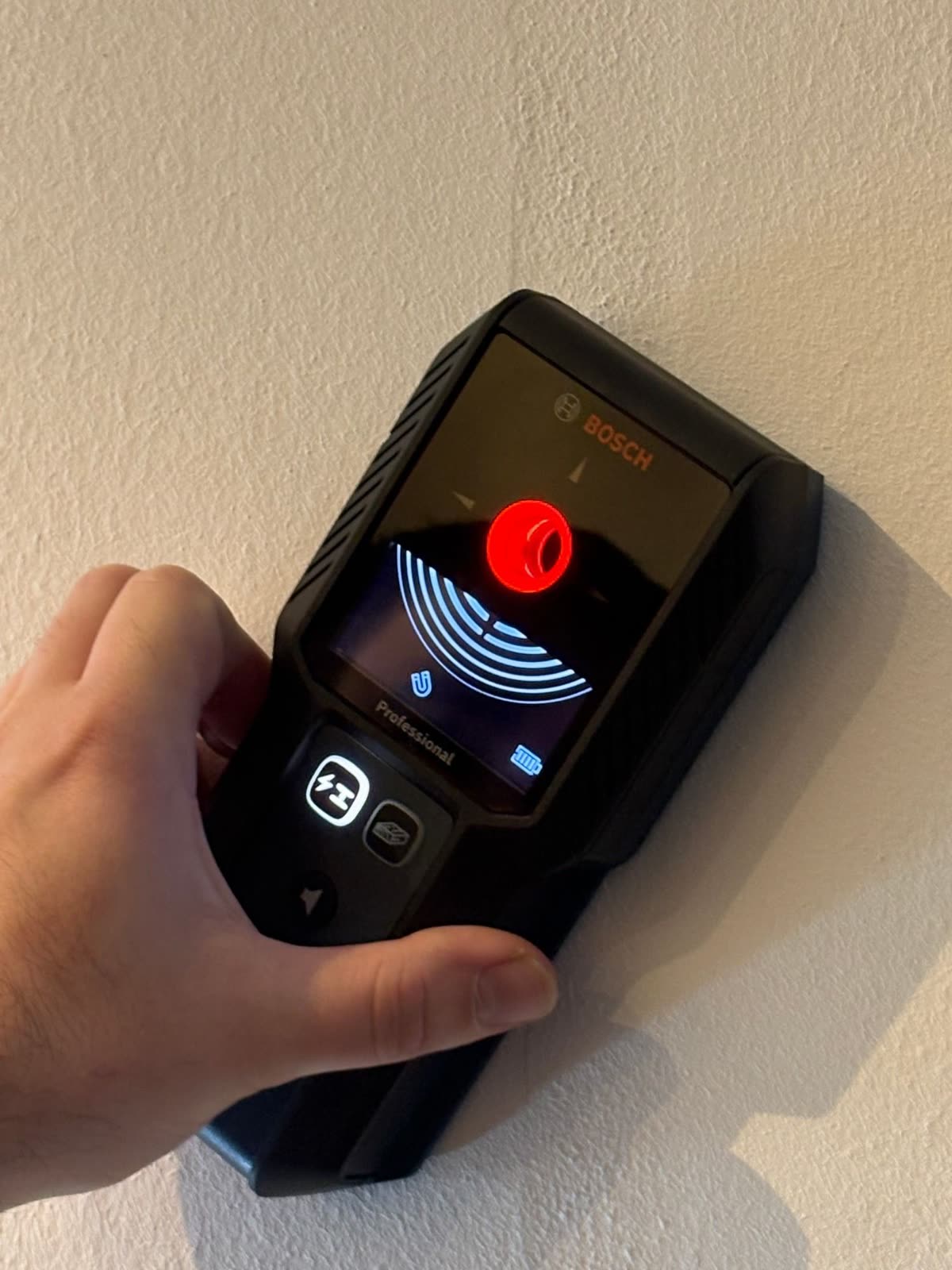 Detektor na zdi svítí červeně: ve zdi vede kabel, sem se vrtat nebude